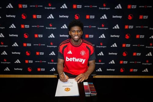 Baleba rạng rỡ trong ngày ký hợp đồng với MU. Ảnh: Manchester United.