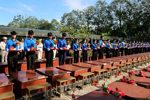 Các đại biểu, lực lượng vũ trang, đoàn viên thanh niên thực hiện Lễ truy điệu 38 liệt sĩ.