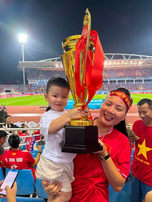 Mẹ Nguyễn Quang Hải bế con trai của tiền vệ tuyển Việt Nam, chụp ảnh với mô hình chiếc cúp trên khán đài Mỹ Đình. Gia đình có mặt để cổ vũ Quang Hải trong trận chung kết lượt về gặp Thái Lan. Sau bàn thắng quan trọng của anh tại lượt đi, người thân kỳ vọng Quang Hải cùng đồng đội tiếp tục thi đấu chắc chắn, giữ vững lợi thế và nâng cúp trước hàng vạn khán giả có mặt tại sân Mỹ Đình.