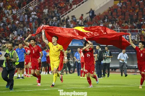 Quốc kỳ Việt Nam nhuộm đỏ sân Mỹ Đình. Các cầu thủ ăn mừng trong niềm tự hào dân tộc.
