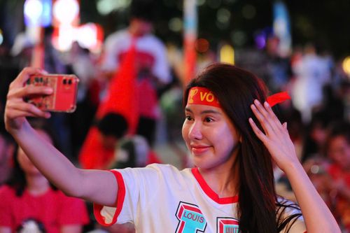 Một bạn trẻ tranh thủ 'check in' trong khi chờ xem trận đấu.