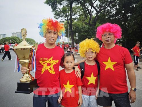 Các cổ động viên cầm trên tay phiên bản cúp vàng để cổ vũ cho chiến thắng của đội nhà. Ảnh: Nam Sương - TTXVN