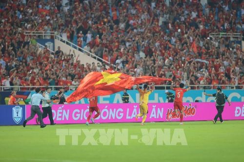 Thủ môn Lê Giang Patrik cùng đồng đội giương cao lá quốc kỳ Việt Nam chạy quanh sân sau khi trận đấu kết thúc. Ảnh: Minh Quyết - TTXVN 