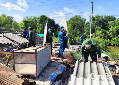 Cán bộ, chiến sĩ Đồn Biên phòng Đất Mũi phối hợp cùng các lực lượng địa phương hỗ trợ vận chuyển mái tôn