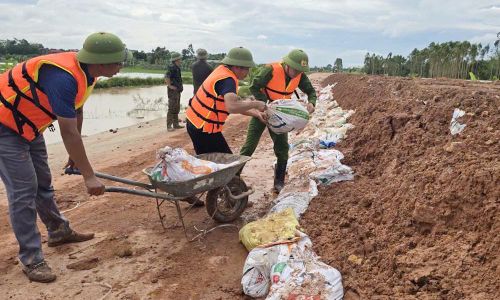  Lực lượng chức năng hỗ trợ xã Bố Hạ gia cố bờ bao ngăn nước tràn vào khu dân cư. 