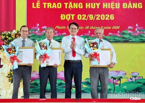 Lãnh đạo xã Phước Hậu trao Huy hiệu 30 năm tuổi Đảng và tặng hoa chúc mừng các đảng viên.