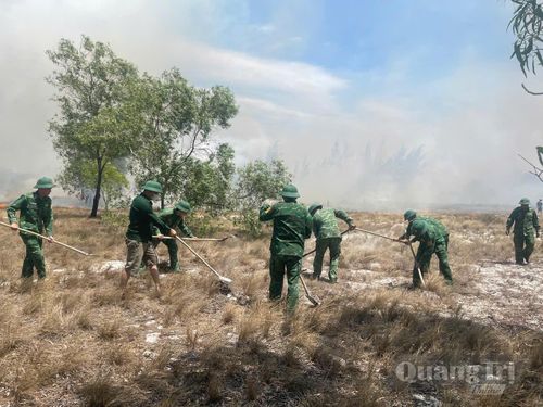 Các lực lượng chức năng triển khai khoanh vùng cản lửa nhằm ngăn chặn cháy lan - Ảnh: Đồn Biên phòng Hải An cung cấp