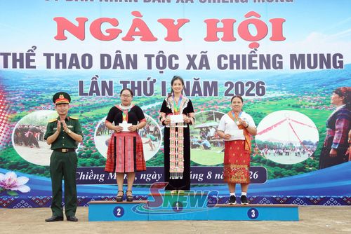Ban tổ chức trao giải cho vận động viên nữ đoạt thành tích môn bắn nỏ.