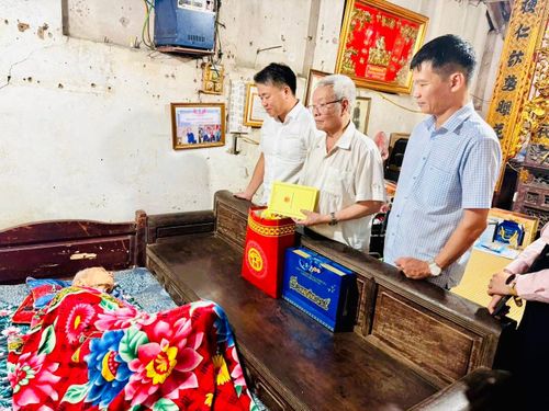 Đại diện lãnh đạo phường Hoàng Mai thăm hỏi, tặng quà và chúc sức khỏe cụ Nguyễn Văn Úc - cán bộ bị địch bắt tù, đày. Ảnh: Tuyết Thanh.