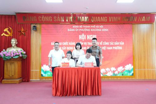 Trưởng ban Xây dựng Đảng và Chủ tịch Ủy ban MTTQ Việt Nam phường Khương Đình ký biên bản bàn giao chức năng, nhiệm vụ tham mưu về công tác dân vận sang Ủy ban MTTQ Việt Nam phường. Ảnh: Hồng Thái