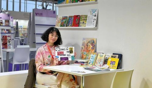  Bà Thanh Quỳnh, đại diện đơn vị làm sách Du Bút, tại Hội sách Thiếu nhi Bologna 2026. Trên tay bà là catalog truyện tranh Việt Nam. Ảnh: NVCC.