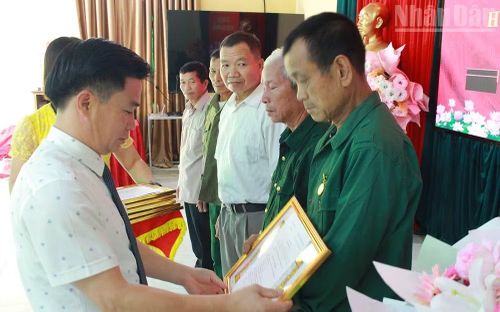 Đồng chí Phan Quý Dương, Bí thư Đảng ủy xã Mường Bang, trao tặng Huy hiệu Đảng﻿ cho các đảng viên. (Ảnh: THÁI BÌNH)