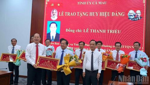 Bí thư Tỉnh ủy Cà Mau Nguyễn Hồ Hải (bìa trái) và Chủ tịch Hội đồng nhân dân tỉnh Phạm Văn Thiều (bìa phải) trao Huy hiệu Đảng 35 năm, Khánh vàng và tặng hoa chúc mừng cho đồng chí Lê Thanh Triều, Ủy viên Ban Thường vụ Tỉnh ủy, Phó Chủ tịch Thường trực Ủy ban Mặt trận Tổ quốc Việt Nam tỉnh Cà Mau. (ảnh HỮU TÙNG).