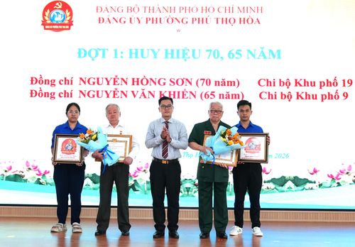 Bí thư Đảng ủy phường Phú Thọ Hòa Phạm Hưng Quốc Bảo trao Huy hiệu Đảng đến các đảng viên