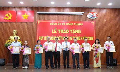 Đồng chí Trần Văn Tuấn cùng Bí thư Đảng ủy xã Đông Thạnh Nguyễn Văn Tuyên trao Huy hiệu Đảng đến đảng viên