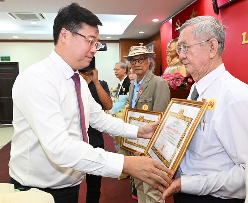 Phó Bí thư Thường trực Thành ủy TPHCM Lê Quốc Phong trao Huy hiệu Đảng đến các đảng viên cao niên. Ảnh: VIỆT DŨNG