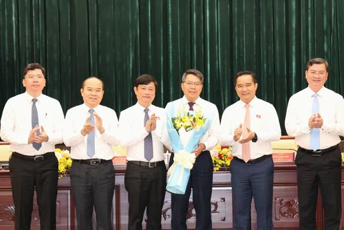 Chủ tịch HĐND TPHCM Võ Văn Minh (thứ 3 từ trái qua), Chủ tịch UBND TPHCM Nguyễn Văn Được (thứ hai từ trái qua) trao hoa chúc mừng ông Lê Văn Thăng. Ảnh: Ngô Tùng