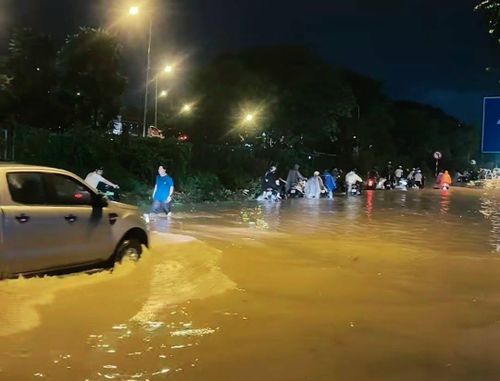 Người dân dắt xe, lội nước tại đường gom Đại lộ Thăng Long.