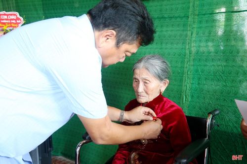 Phó Chủ tịch UBND tỉnh Hồ Huy Thành trao Huy hiệu 80 năm tuổi Đảng cho đồng chí Nguyễn Thị Nguyệt.