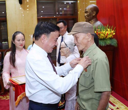 Thường trực Ban Bí thư Trần Cẩm Tú gắn Huy hiệu 80 năm tuổi Đảng cho đảng viên lão thành Hồ Văn Lang. Ảnh: Phương Hoa - TTXVN