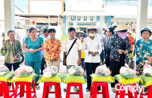 Đại diện Công ty CP Đầu tư và Thẩm định giá Sao Việt - Chi nhánh Tây Đô và Công ty TNHH Đo đạc và Dịch vụ Đất Mới trao quà cho người dân.