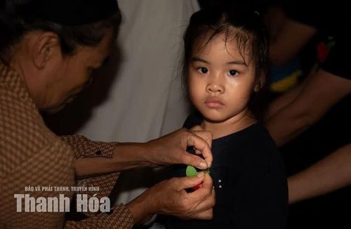 Bà ân cần cài bông hoa nhỏ lên ngực áo cháu, nhẹ nhàng truyền trao hạt mầm hiếu thuận.