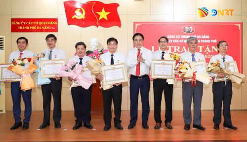 Phó Bí thư Thường trực Thành ủy, Bí thư Đảng ủy Các cơ quan Đảng thành phố Nguyễn Khắc Toàn (thứ 4, bên phải sang) trao Huy hiệu 35 năm tuổi Đảng cho các đảng viên đủ tiêu chuẩn. Ảnh: NGỌC PHÚ