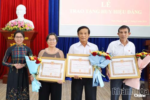 Thường trực Đảng ủy xã Ninh Phước trao Huy hiệu 45 năm tuổi Đảng và tặng hoa chúc mừng các đảng viên.