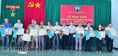 Thường trực Đảng ủy xã Phước Hữu trao Huy hiệu Đảng và tặng hoa chúc mừng các đảng viên.