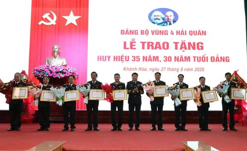 Đại tá Bùi Xuân Bình trao quyết định, tặng hoa chúc mừng các đảng viên nhận Huy hiệu 35 năm tuổi Đảng