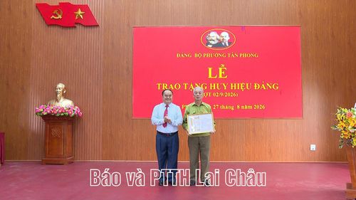 Bí thư Đảng ủy phường Tân Phong Mùa A Trừ trao Huy hiệu 55 năm tuổi Đảng cho đảng viên Vũ Hồng Khanh. 