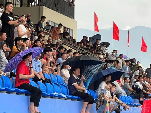 Khán giả đội mưa cổ vũ các đội bóng.
