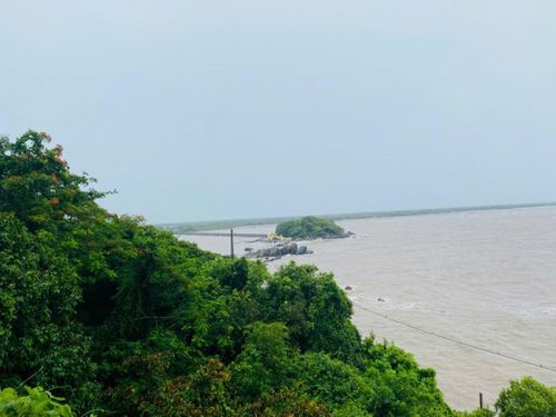 Toàn cảnh Hòn Đá Bạc nhìn từ trên cao với cây cầu nối đất liền ra cụm đảo, nổi bật giữa màu xanh của biển và rừng ngập mặn