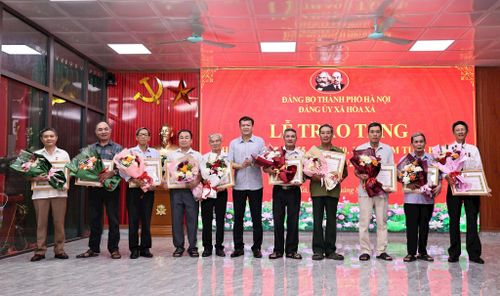 Phó Bí thư Thường trực Đảng ủy xã Hòa Xá Trần Duyên Hải trao Huy hiệu Đảng tặng các đảng viên. Ảnh: Thanh Hằng