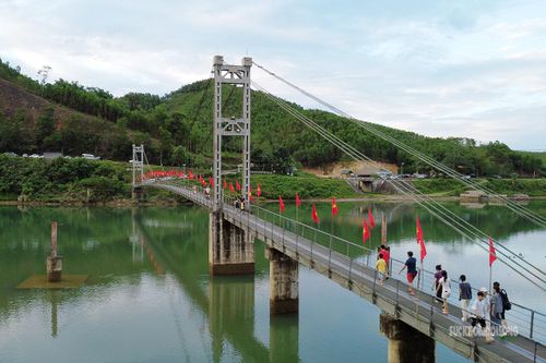 Người dân và du khách qua lại trên cầu Bản Mạ. Ảnh: T.Anh