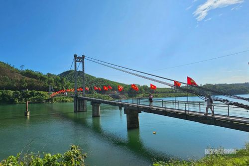 Cờ Tổ quốc nổi bật trên cây cầu giữa núi rừng. Ảnh: T.Anh