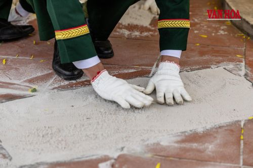 Đôi tay người lính cẩn trọng san lại lớp đất trên phần mộ đồng đội, một chi tiết nhỏ nhưng gợi nhiều xúc cảm trong phút cuối lễ an táng