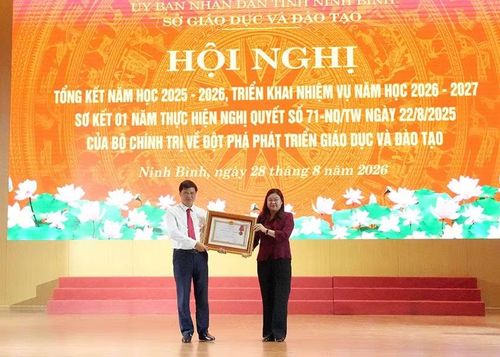 Thừa ủy quyền, đồng chí Phó Chủ tịch Ủy ban nhân dân tỉnh Hà Lan Anh trao Huân chương Lao động hạng Nhất của Chủ tịch nước cho tập thể Trường trung học phổ thông Nam Lý, xã Nam Lý. (Ảnh: HÀ NAM)