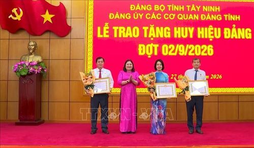 Ủy viên BCH Trung ương Đảng, Phó Bí thư Thường trực Tỉnh ủy Tây Ninh Hồ Thị Hoàng Yến trao Huy hiệu Đảng cho các đảng viên. Ảnh: Thanh Bình/TTXVN