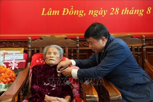 Thừa ủy quyền của Ban Bí thư, đồng chí Y Thanh Hà Niê Kđăm trao tặng Huy hiệu 80 năm tuổi Đảng cho cụ Lê Thị Dục. Ảnh: Nguyễn Dũng/TTXVN