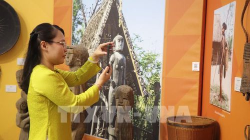 Khách tham quan thích thú check QR để tìm hiểu về văn hóa các dân tộc thiểu số. Ảnh: Nguyễn Hằng - TTXVN