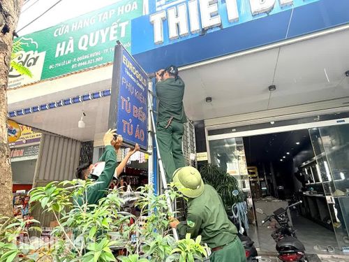 Các lực lượng chức năng tiến hành tháo dỡ các biển quảng cáo lắp đặt không đúng quy định tại đường Lê Lai, phường Quảng Phú