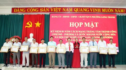 Thành ủy viên, Bí thư Đảng ủy, Chủ tịch HĐND phường Long Thành Nguyễn Hữu Nguyên (thứ 6 từ phải qua) và các đồng chí trong Thường trực Đảng ủy trao Huy hiệu Đảng cho các đảng viên. Ảnh: ĐPCC