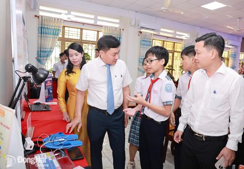 Phó Bí thư Đảng ủy, Chủ tịch UBND phường Trảng Bom Lê Ngọc Tiên và Phó Chủ tịch UBND phường Trảng Bom Nguyễn Văn Chiến nghe các học sinh của phường giới thiệu các mô hình sáng chế đạt giải cao tại cuộc thi khoa học, kỹ thuật cấp thành phố năm học 2025-2026 tại buổi lễ công bố.