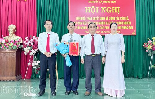 Thường trực Đảng ủy xã Phước Hữu trao quyết định và tặng hoa chúc mừng ông Phan Ngọc Thành.