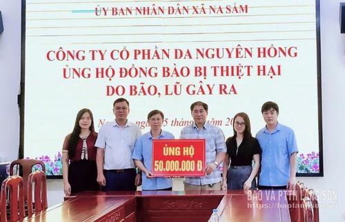 Đại diện doanh nghiệp trao biểu trưng kinh phí hỗ trợ người dân xã Na Sầm khắc phục hậu quả sau bão