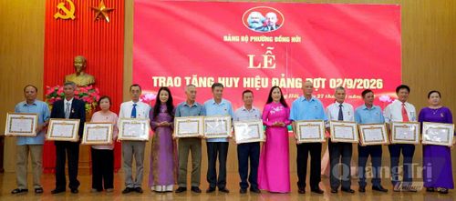 Đại diện lãnh đạo phường Đồng Hới trao tặng và chúc mừng các đảng viên lão thành - Ảnh: P.V