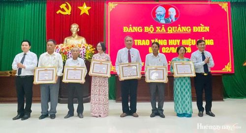 Thường trực Đảng ủy xã Quảng Điền trao Huy hiệu Đảng cho các đảng viên. Ảnh: Phong Anh 