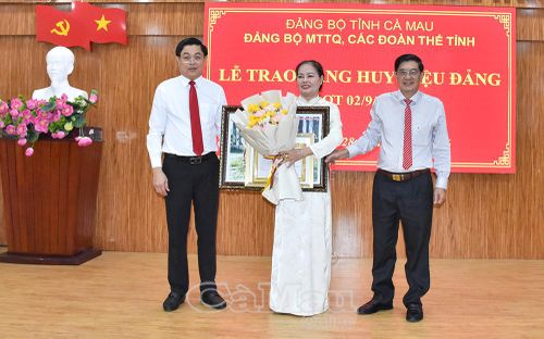 Đồng chí Phạm Minh Luyến và đồng chí Trương Dũng Tiến trao Huy hiệu 30 năm tuổi Đảng và tặng hoa chúc mừng đồng chí Đoàn Kim Thuyền. 