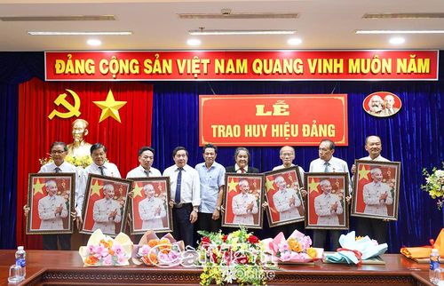  Đồng chí Lê Bình Nguyên và đồng chí Lê Hoài Bảo trao ảnh Bác Hồ tặng các đảng viên nhận Huy hiệu 35 năm tuổi Đảng.